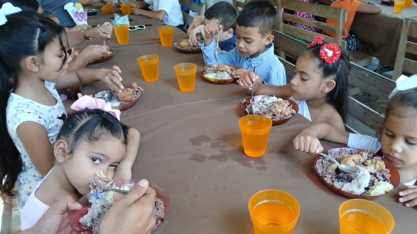 Children enjoying a meal together at a feeding event