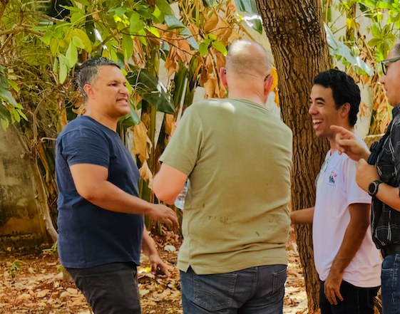 Charlie Coe and Pastor Luis's congregation greeting one another