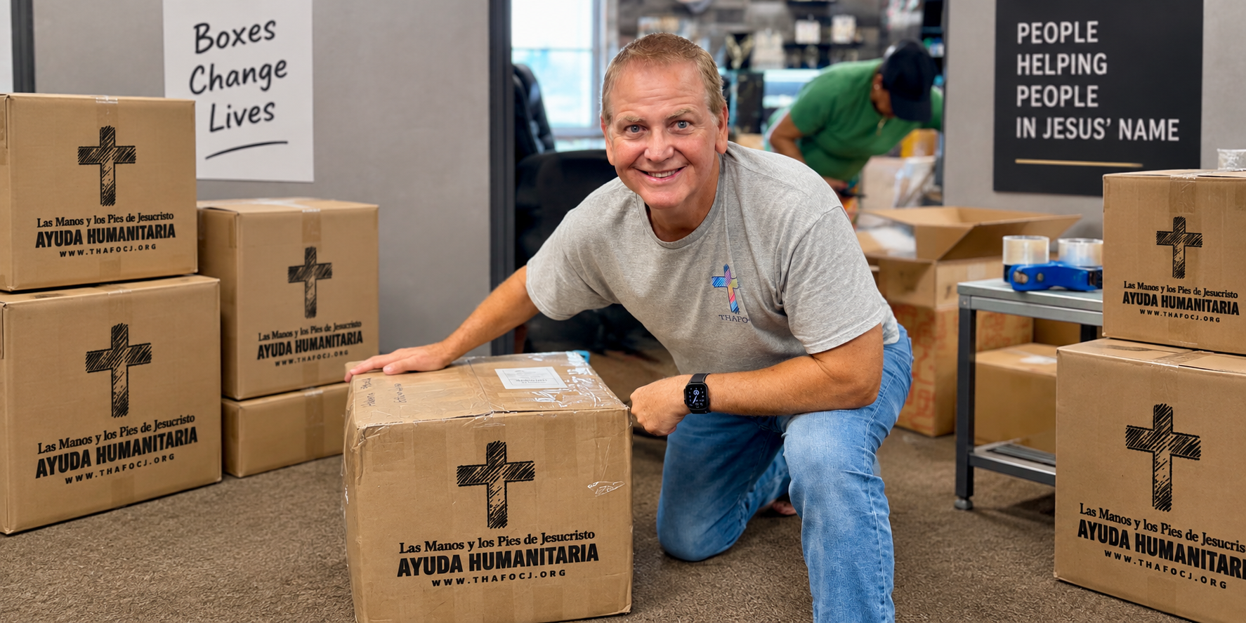 Steven Wissinger kneeling with a Support Box surrounded by boxes ready for shipment to Cuba