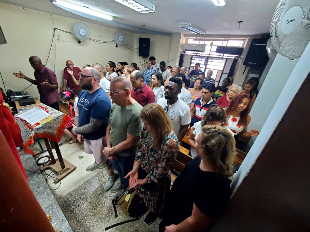 Volunteers and children sharing a meal together at a mission feeding event in Cuba