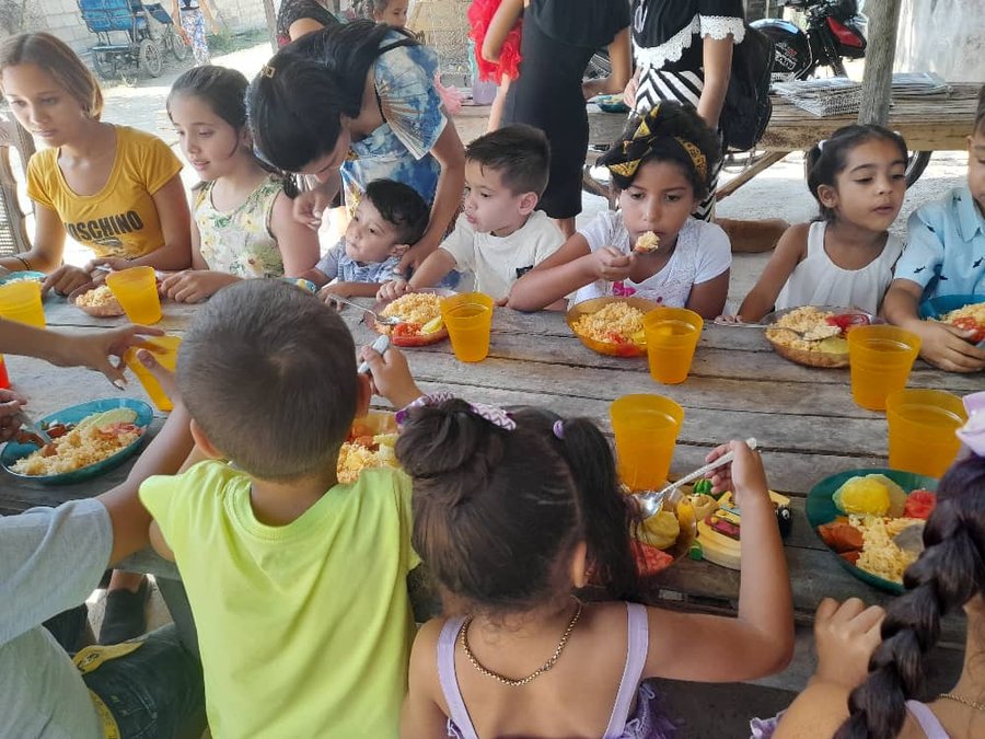 Children eating a meal together at the August 2026 Cuba mission